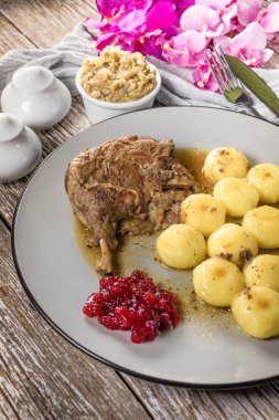 Kızarmış ördek bacağı, patates köftesi ve kızılcık..