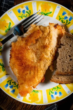 Ekmek dilimleriyle servis edilen kızarmış morina filetosu. Sığ alan derinliği.