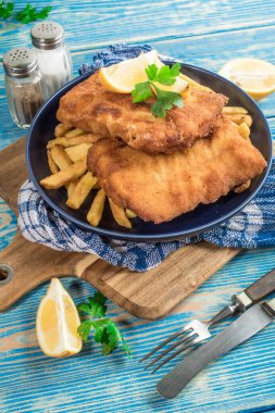 Tabağında patates kızartması olan kızarmış morina balığı..