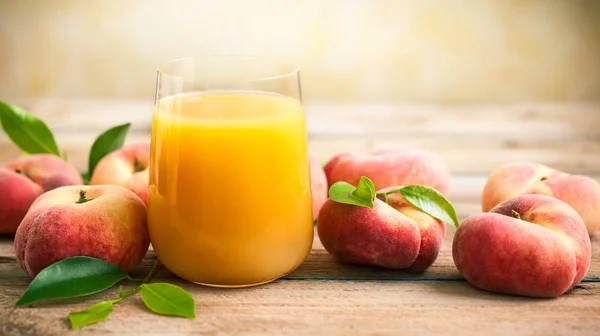 Pahar Suc Proaspăt Piersici Înconjurat Fructe Proaspete Frunze Masa Lemn — Fotografie, imagine de stoc