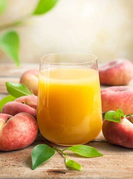 Ein Glas Frischen Pfirsichsaft Umgeben Von Frischen Früchten Mit Blättern — Stockfoto