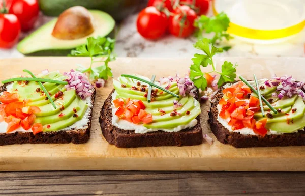 Čerstvé Vegetariánské Sendviče Černý Chléb Avokádem Rajčaty Červenou Cibulí Dřevěné — Stock fotografie