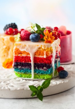 Çeşitli dilim kek beyaz bir tepsi: gökkuşağı kek, ahududu cake ve badem pasta. Tatlılar taze meyveler ve çiçekler ile tatil için dekore edilmiş