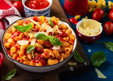 Baharatlı domates sos, parmesan ve fesleğen ile makarna. Makarna Chifferi Rigati.