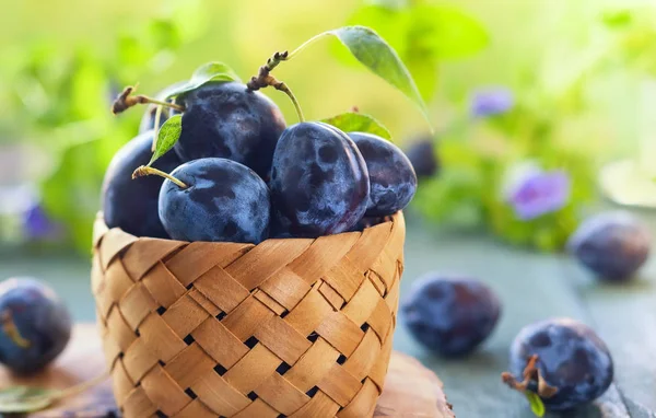 Prugne Fresche Con Foglie Cesto Fondo Legno — Foto Stock