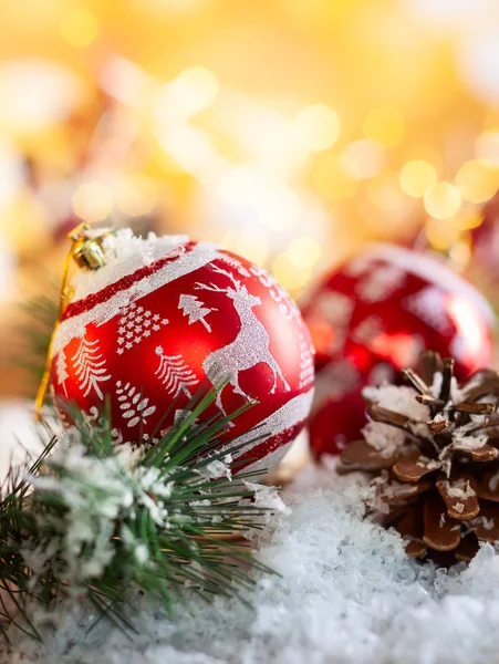 红色圣诞节球与装饰和杉木树枝与松树锥上金色闪亮的背景 — 图库照片