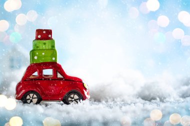 Noel hediyeleri karlı manzarada taşıyan kırmızı oyuncak araba. Noel kavramı kopya alanı ile.