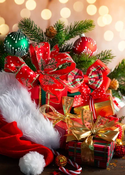 サンタ クロースの赤い帽子 クリスマス ボール 木製の背景にギフト ボックスのクリスマス休日コンポジション — ストック写真