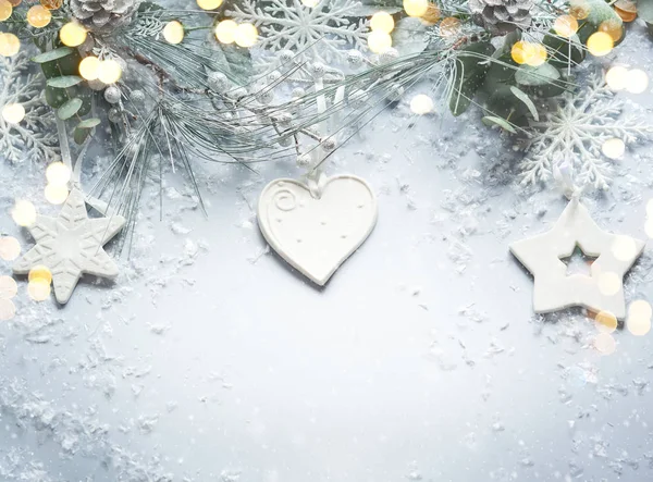 雪のモミの枝と光の背景に松のコーンとクリスマスと新年の休日の概念 クリスマスグリーティングカードトップビュー — ストック写真