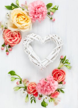 Güzel bahar çiçekleri Beyaz ahşap zemin üzerinde. Ahşap dalları yürekten ile şenlikli çiçek kompozisyon. Sevgililer günü ya da anneler günü kavramı. Üstten görünüm.