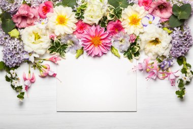 Beyaz ahşap zemin üzerinde tebrik kartı ile şenlikli çiçek kompozisyon. Üstten Görünüm