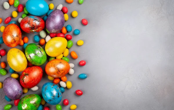 五颜六色的复活节彩蛋和巧克力复活节糖果在灰色的背景 带有复制空间的顶部视图 节日复活节概念 — 图库照片