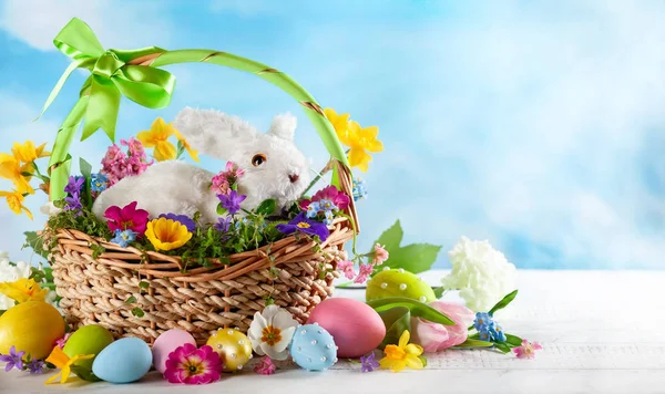 Osterkomposition Mit Kleinen Weißen Hasen Korb Frühlingsblumen Und Bunten Ostereiern — Stockfoto