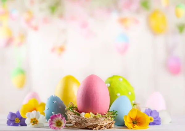 Osterkomposition mit bunten Ostereiern und Frühlingsblumen — Stockfoto