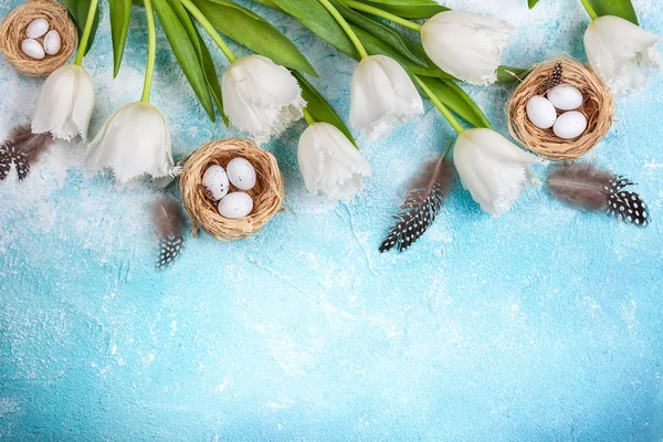 Easter composition with Easter eggs in nest and white tulips — Stock Photo, Image