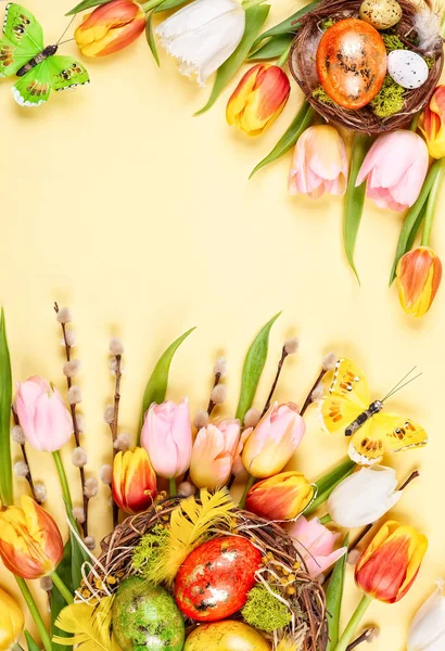 Velikonoční složení s Velikonocemi v hnízdě a jarních květech — Stock fotografie