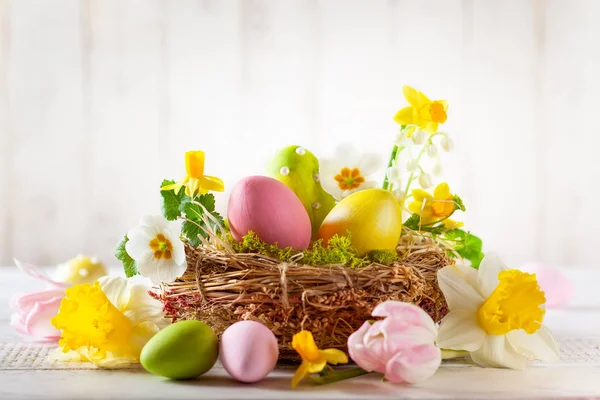 Påsk sammansättning med påskägg i boet, vårblommor och — Stockfoto