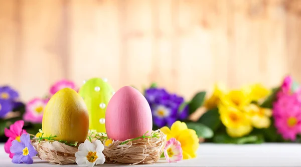 Composizione pasquale con uova di Pasqua colorate e fiori primaverili — Foto Stock