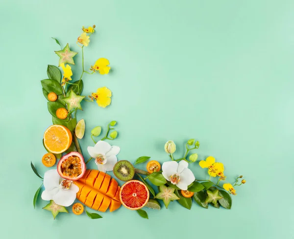 Summer composition with fruits and flowers on blue background.