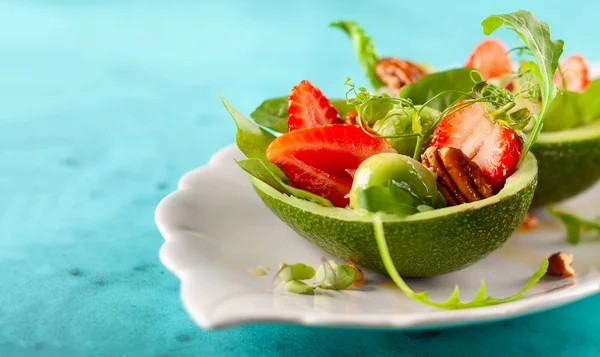 Gefüllte Avocado mit Erdbeeren und Nüssen . — Stockfoto