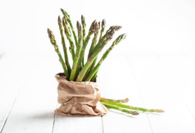 Kağıt torbada bir demet yeşil kuşkonmaz