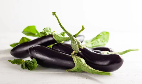 Fresh eggplants on a white wooden table. — Stock Photo, Image