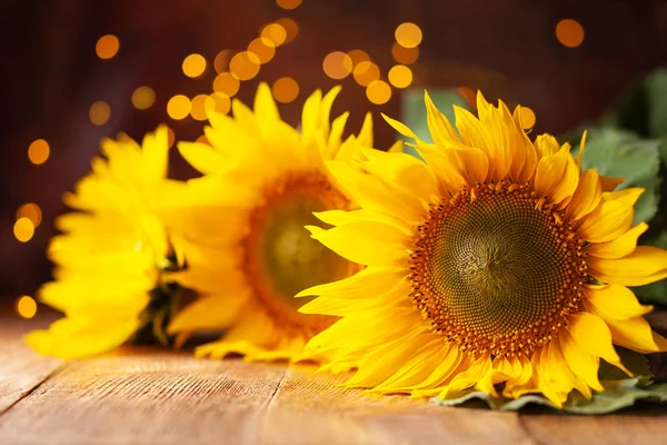 Hermosos girasoles amarillos sobre mesa de madera en bokeh bac festivo — Foto de Stock