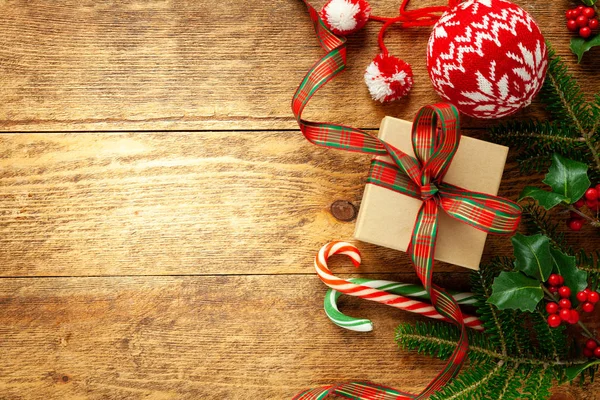 Vánoční pozadí s dárkovou krabicí, větve cesmíny a jedle na — Stock fotografie