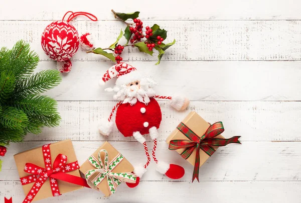 Kerst achtergrond met geschenkdozen, kerstman speelgoed en tak — Stockfoto