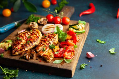 Izgara tavuk göğsü ve ahşap tahtada servis edilen mantarlı mantar reklamı. Manzarayı kapat. Ev yapımı yaz barbeküsü yemeği.