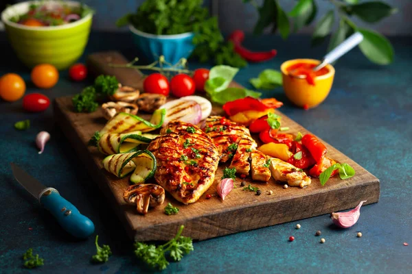 烤鸡胸肉和在木板上烤的不同蔬菜蘑菇 概念自制的夏季烧烤晚餐 — 图库照片