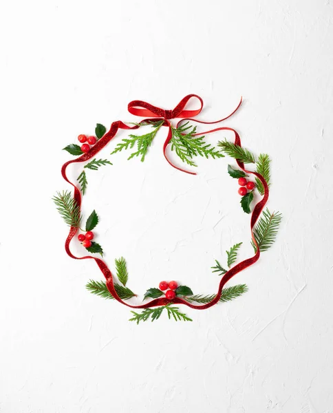 白い背景にクリスマスの泡の形で赤いリボン トウヒの枝 赤い果実とホリーとクリスマスの組成物 メリークリスマス挨拶カード空のスペースのための休日のテキスト — ストック写真