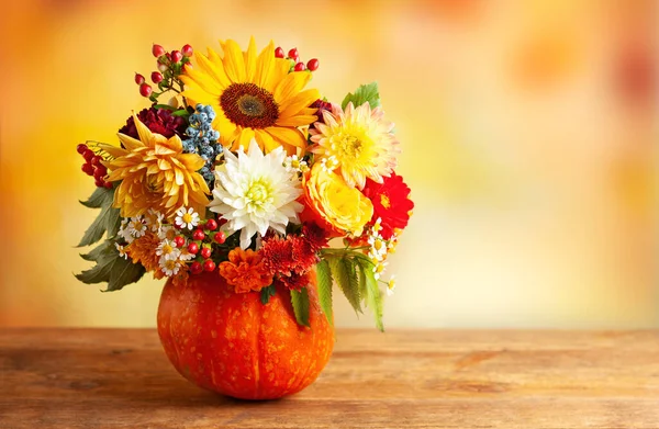 秋天的一束美丽的花朵和浆果 放在木制桌子上的南瓜里 感恩节秋季节日装饰的概念 — 图库照片