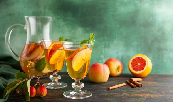 苹果果酸鸡尾酒 配上红色橙子和调味品 还有玻璃杯和茶壶放在桌上 秋冬饮料的概念 — 图库照片