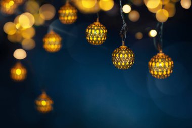 Garland Lights 'ın parlak bokeh' li koyu mavi arka planda olduğu bir festival dekorasyonu. Noel veya Yeni Yıl arkaplanı