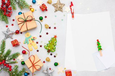Noel arkaplanı hediye kutuları, şenlik dekorları, köknar ağacı dalları ve kağıt kart notları. Düz yatıyordu. Noel ve Yeni Yıl kavramı.