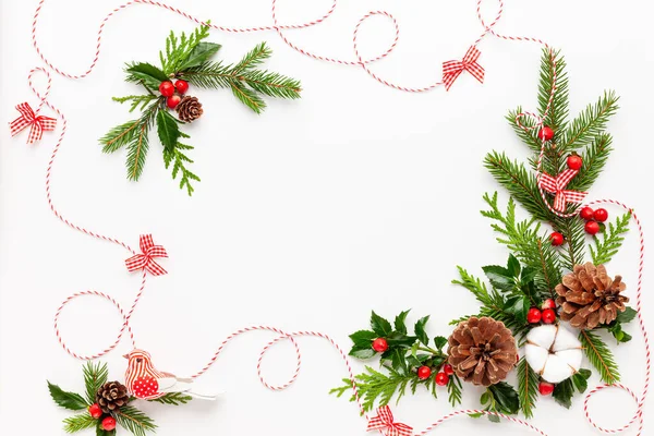 Beyaz arka planda kırmızı böğürtlenli ladin dalları ve çobanpüskülü Noel kompozisyonu. Tatil mesajları için boş yeri olan mutlu noel tebrik kartları. Düz yatıyordu.