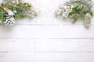Karda çam kozalağı ve beyaz ahşap arka planda retro tarzı saat olan Noel ağacı dalı. Kış ya da Noel festivali konsepti. Düz yat, boşluğu kopyala.