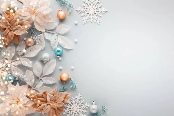 パステルカラーの背景にお祝いの赤ちゃん ポインセチアの花や銀の葉とクリスマスのアレンジ 平置きだ トップビュー コピースペース — ストック写真