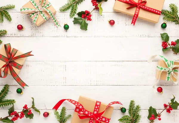 ギフトボックス 白い木製の背景にホリーとモミのクリスマスの装飾や枝を持つクリスマスの背景 冬のお祝いの概念 コピースペース — ストック写真