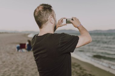 Sahilde bir adam bir arama yapıyor