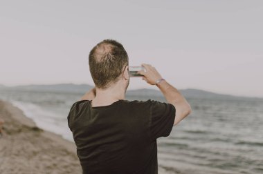 Sahilde bir adam bir arama yapıyor