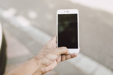 Soyut bulanık sokak gecesinde akıllı telefonu kullanan adam. Grafik ekran montajı için siyah ekran.