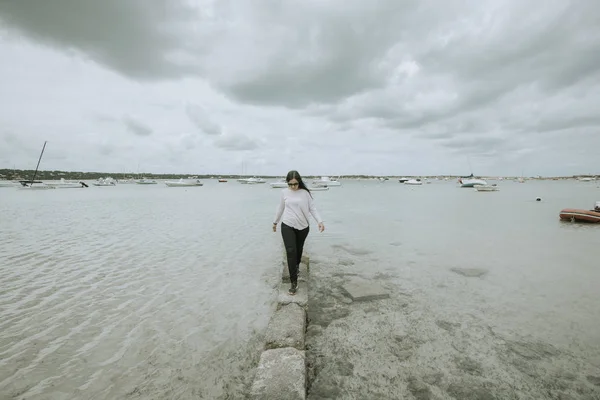 Mujer vestida dando un paseo por la playa — Foto de Stock