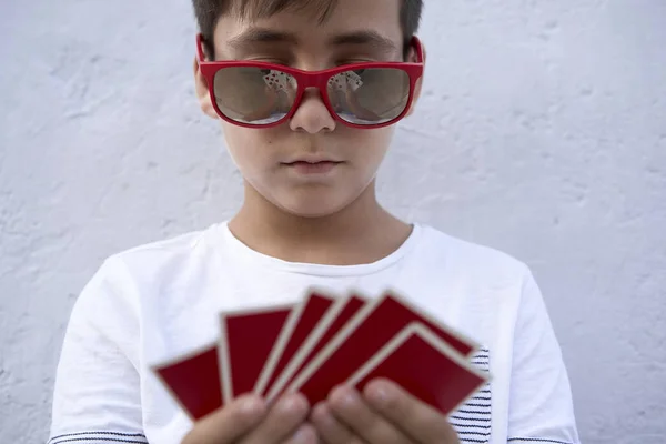 Garçon avec des lunettes de soleil rouges jouer au poker — Photo