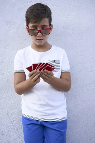 Niño con gafas de sol rojas jugando al poker — Foto de Stock
