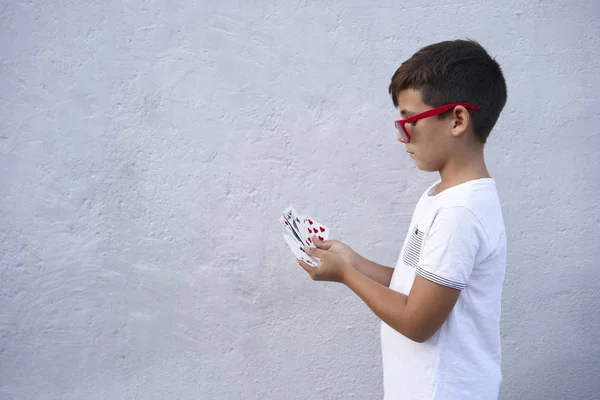 Niño con gafas de sol rojas jugando al poker — Foto de Stock