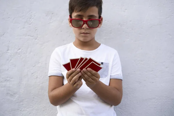 Мальчик в красных очках играет в покер — стоковое фото