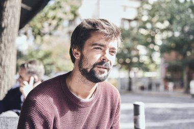 Kafede sigara içen çekici genç sakallı adam.