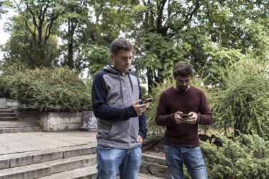 Genç adam sokakta cep telefonunu kullanma
